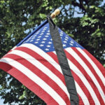 American flag with black mourning ribbon